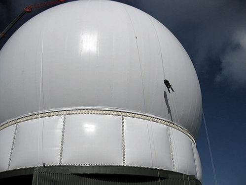 Inspecting a large air supported radome from ropes.