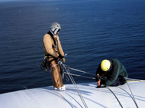 Technicians performs maintenance on air supported radome.