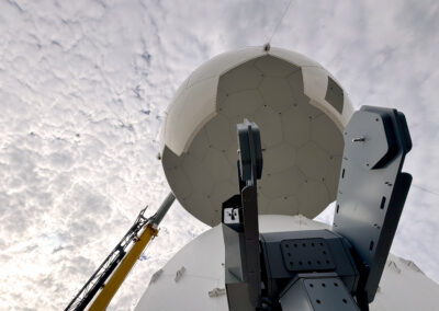 Sheergard radome being lifted over an antenna during installation.